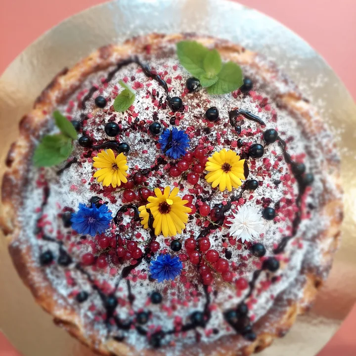 Meidi cake decorated with berries, mint and edible flowers
