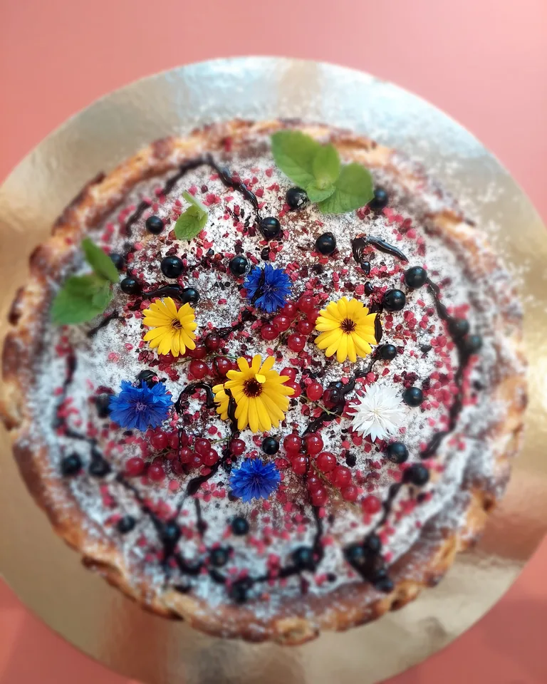 Meidi cake decorated with berries, mint and edible flowers