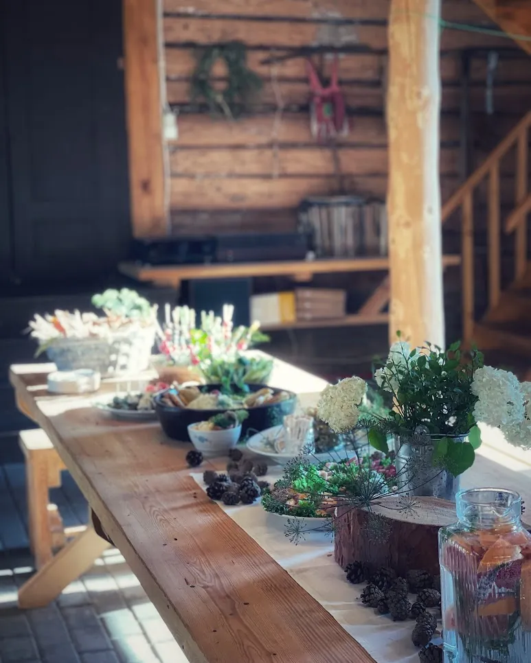A long wooden event table with flowers and served food
