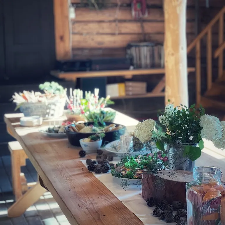 A long wooden event table with flowers and served food