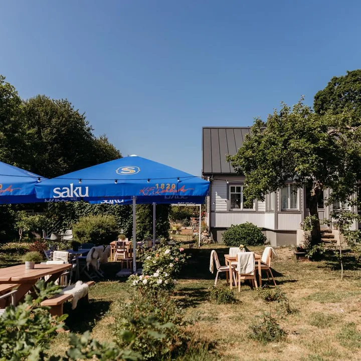 Meidi’s summer courtyard café with garden tables, umbrellas and a wooden house